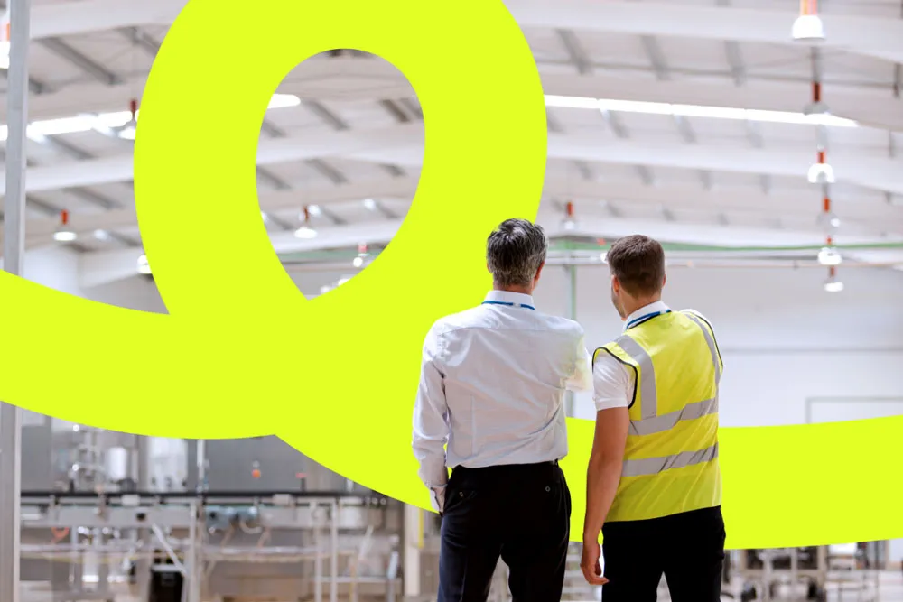 two men overlooking paper production site